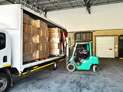 Forklift moving boxes at a distribution point